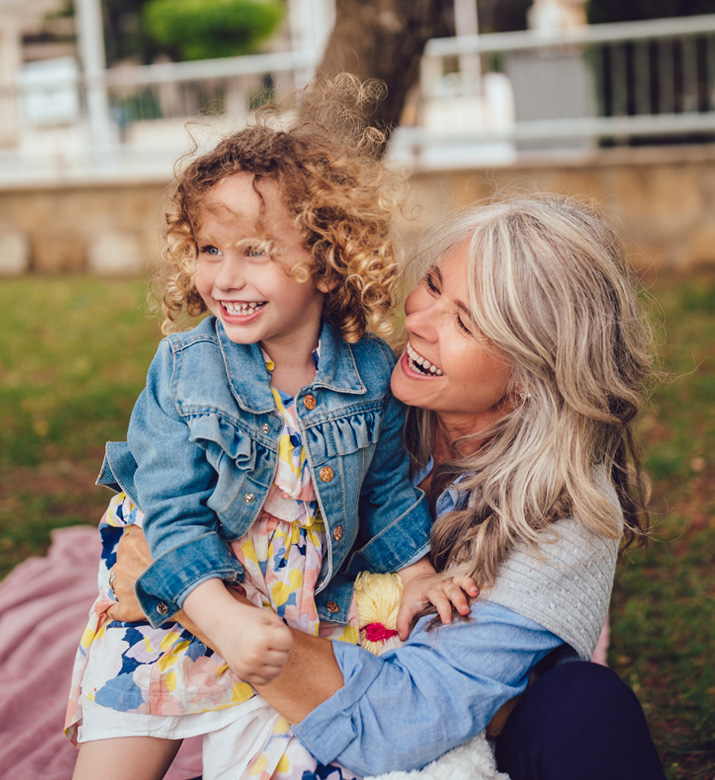 Photo of grandmother and granddaughter smiling together.