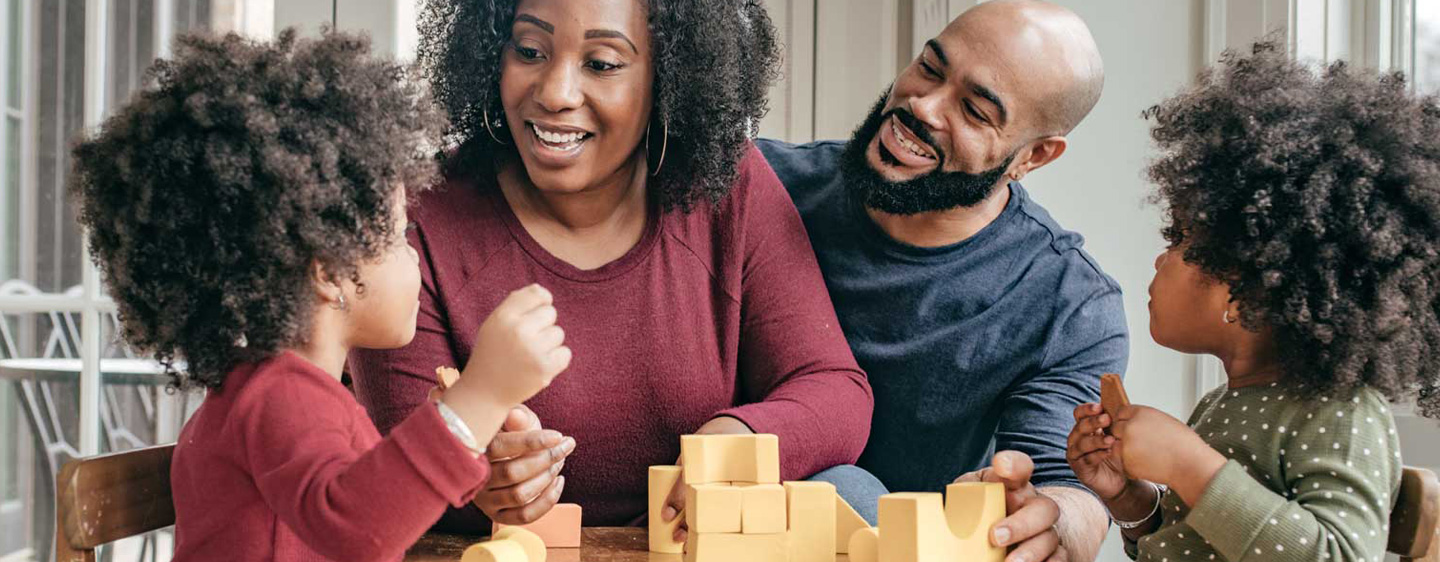 Family playing with blocks together at a table.