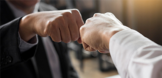 Image of two hands "fist bumping" instead of shaking hands.