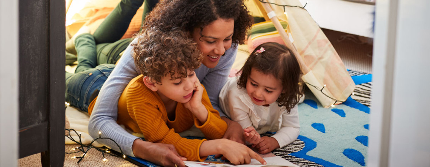 Family relaxes on the floor together.