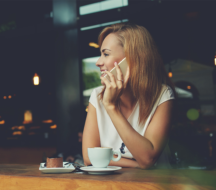 Woman on a cell phone at a coffee shop.
