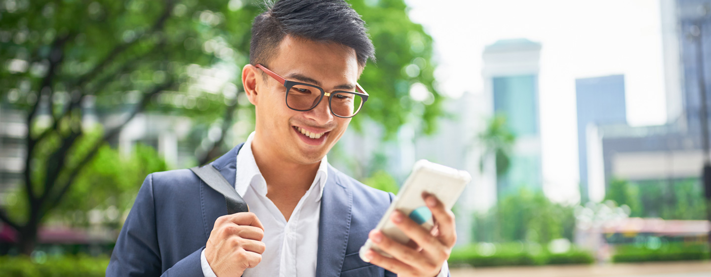 Man uses cellphone outside.