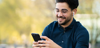 Man smiles while using his phone