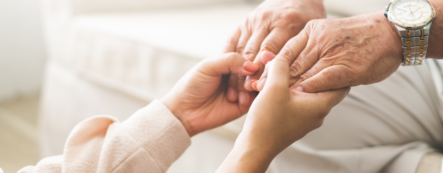 Younger individual holding hands with elder.