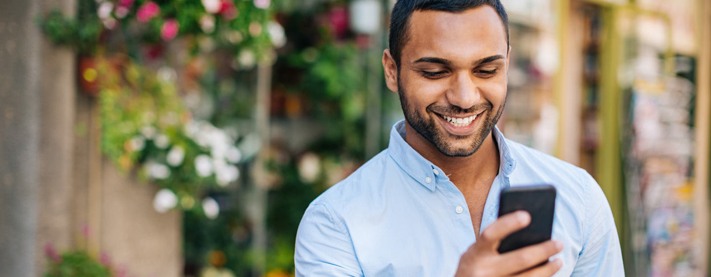 A man smiles at his cellphone.