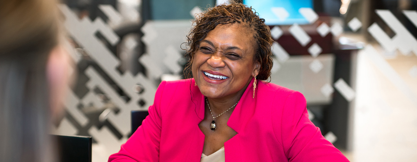 A woman smiles inside a CCU branch.