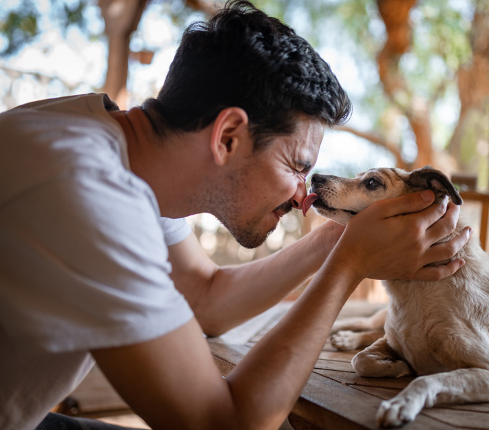 Image of a man being licked on the nose by his dog