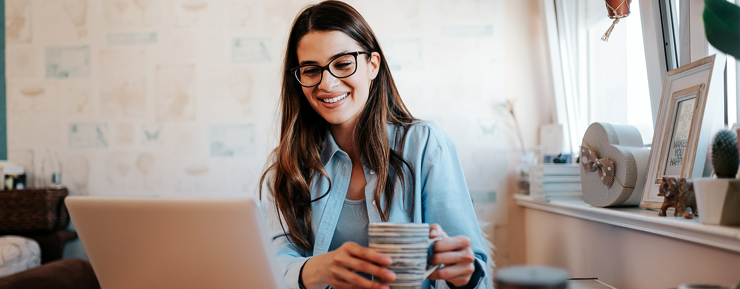 Woman smiling looking at her computer.