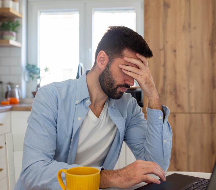 Man distressed at laptop