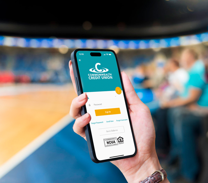 Image of someone holding a phone at a basketball game.