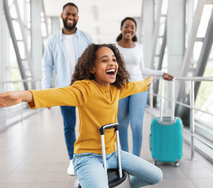 Young girl smiles with family in an airport