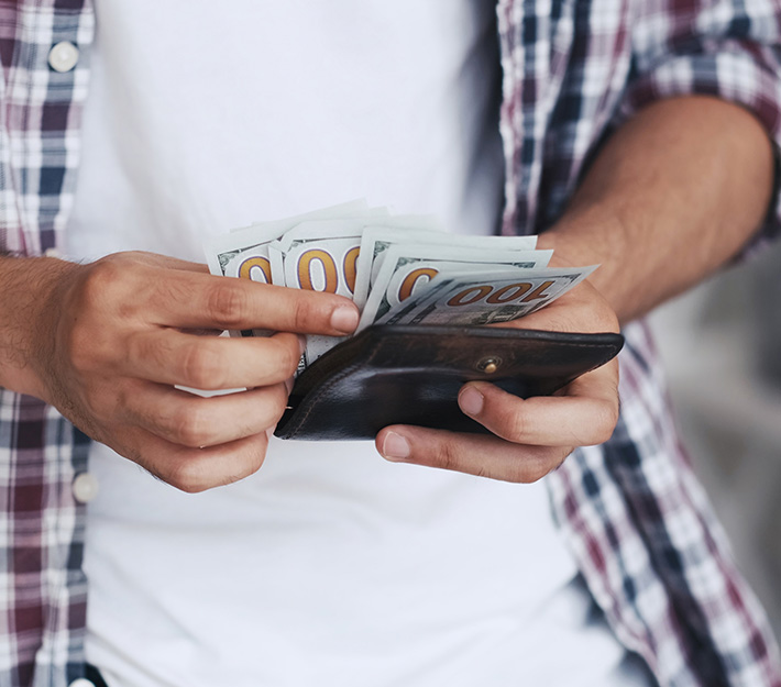 Close up of man holding a wallet and cash