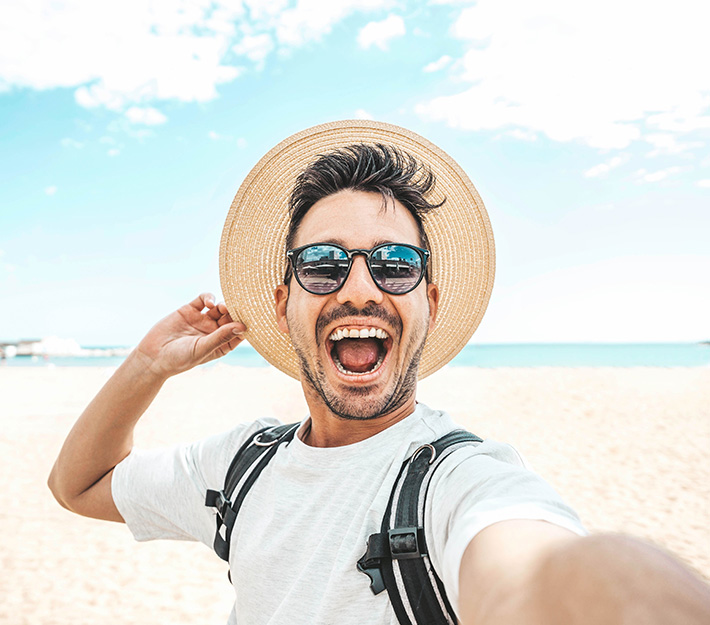 Man smiling taking selfie on beach