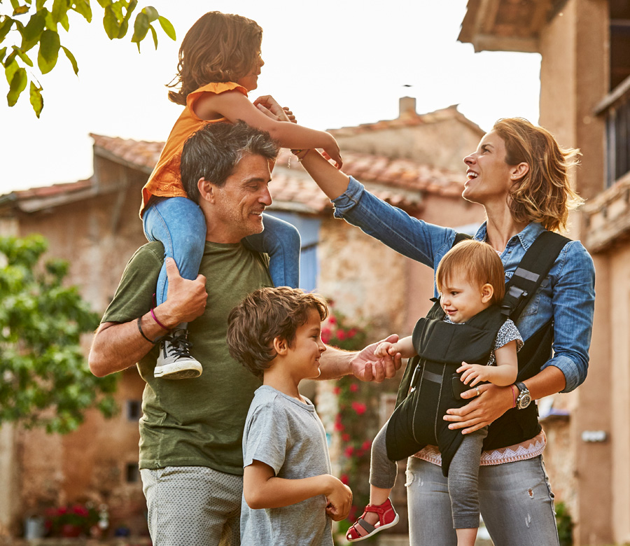 Two parents play and smile with their 3 kids.