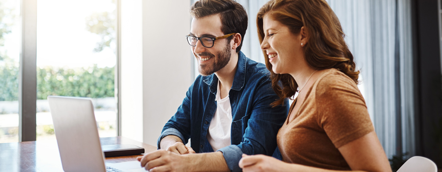 Two people looking at a laptop.