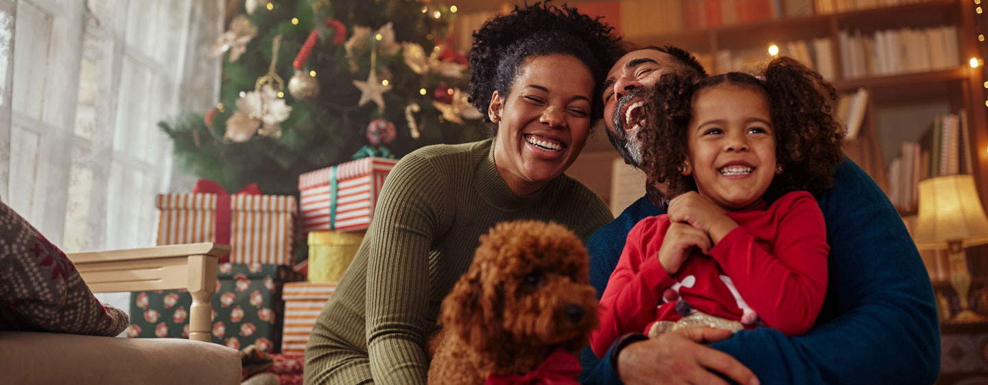 Mom, dad, daughter, and dog at Christmas.