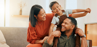 Family smile together on a couch