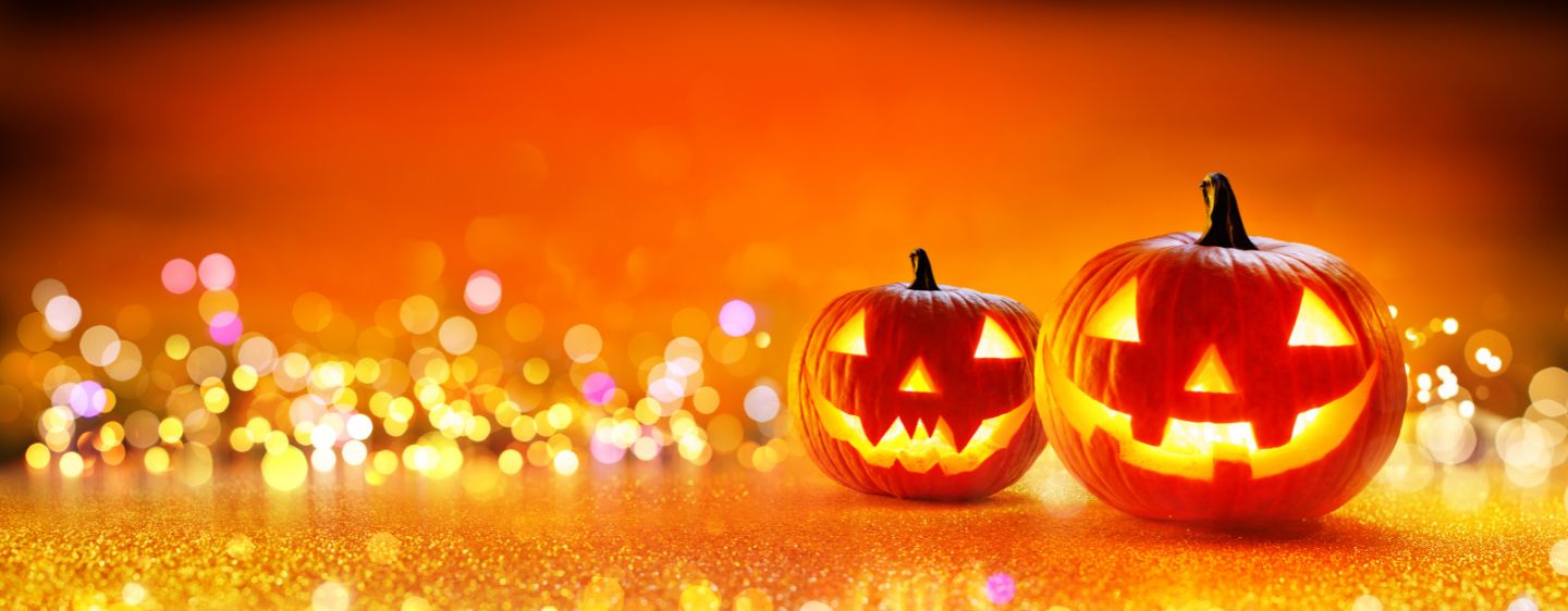 Carved Halloween pumpkins with lighted background.
