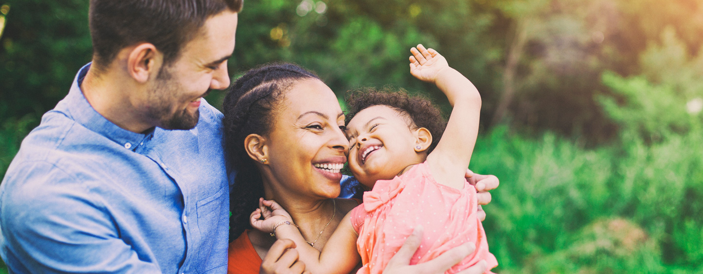 Family smiling outside.