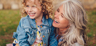 Photo of grandmother and granddaughter smiling together.