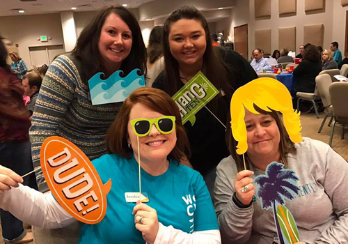 Team members having fun with photo props for a picture.