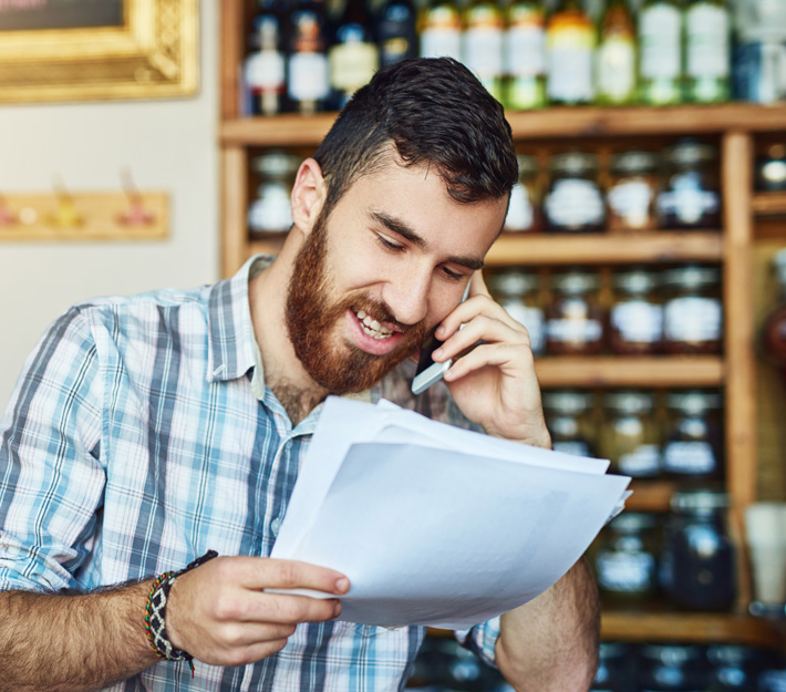 Man on cellphone chatting about paperwork.