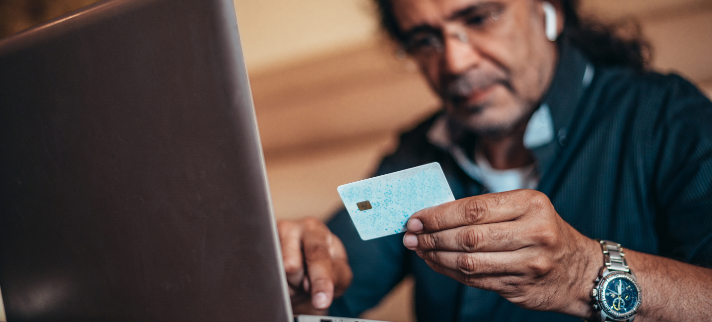 Man looking at credit card info. 