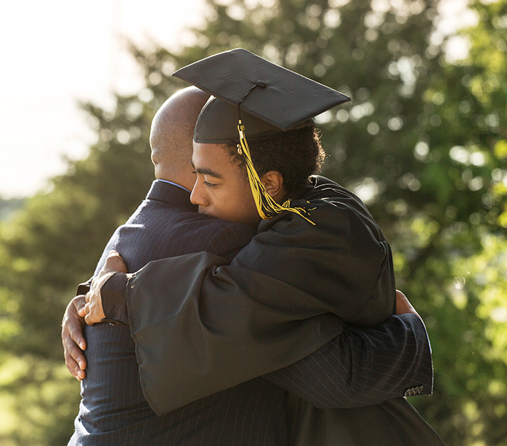 Son hugging his father on graduation day.