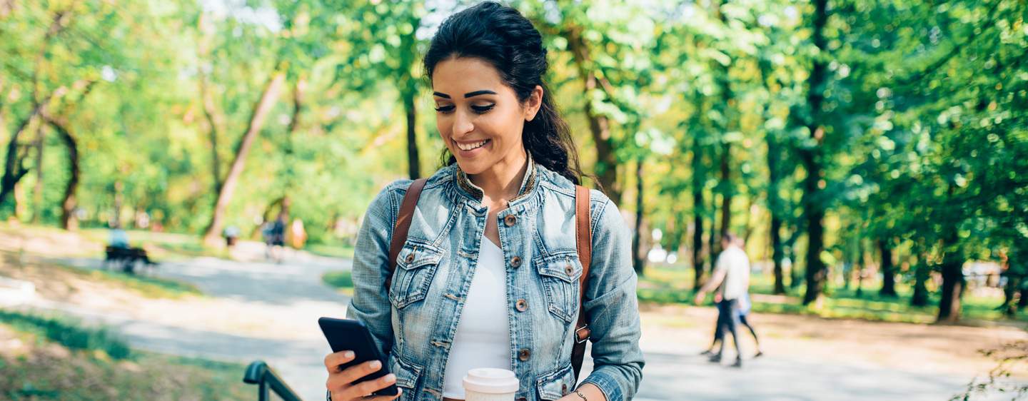 Image of a woman smiling at her phone