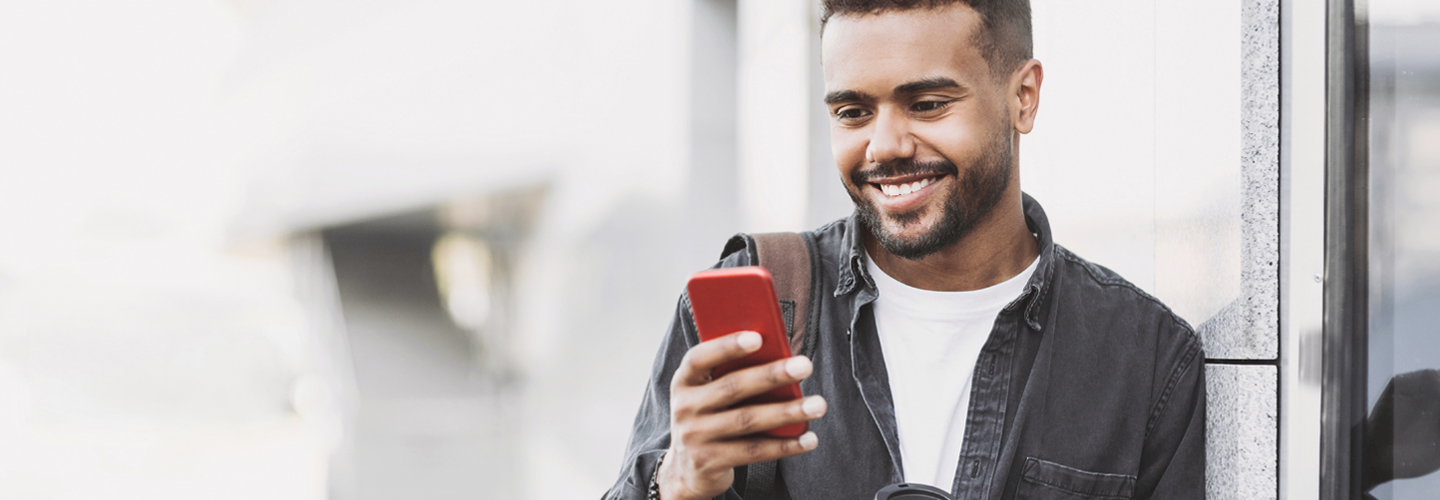 Man smiling at a cellphone.