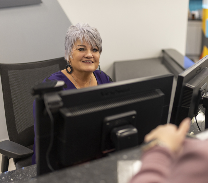 CCU employee sitting behind a computer.