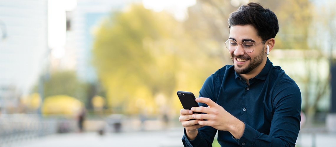 Header image depicting a man using a cell phone and smiling