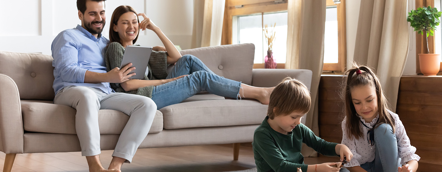 Parent on couch watching kids play in the floor.