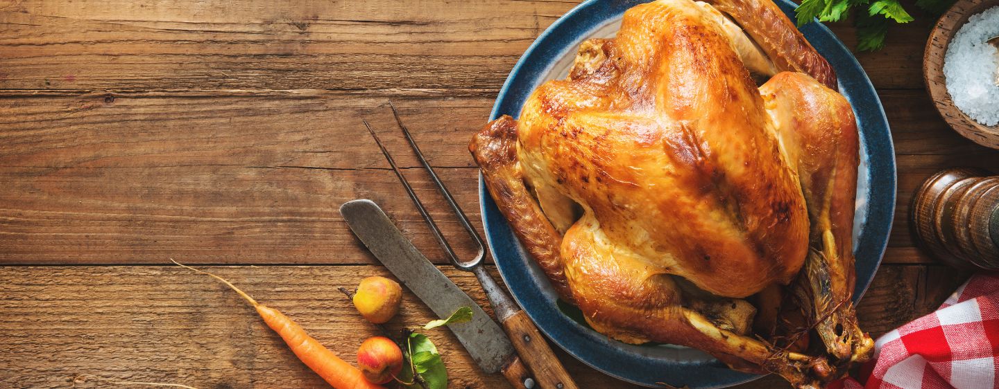 Image of a roasted turkey on a platter, laid out on a table.