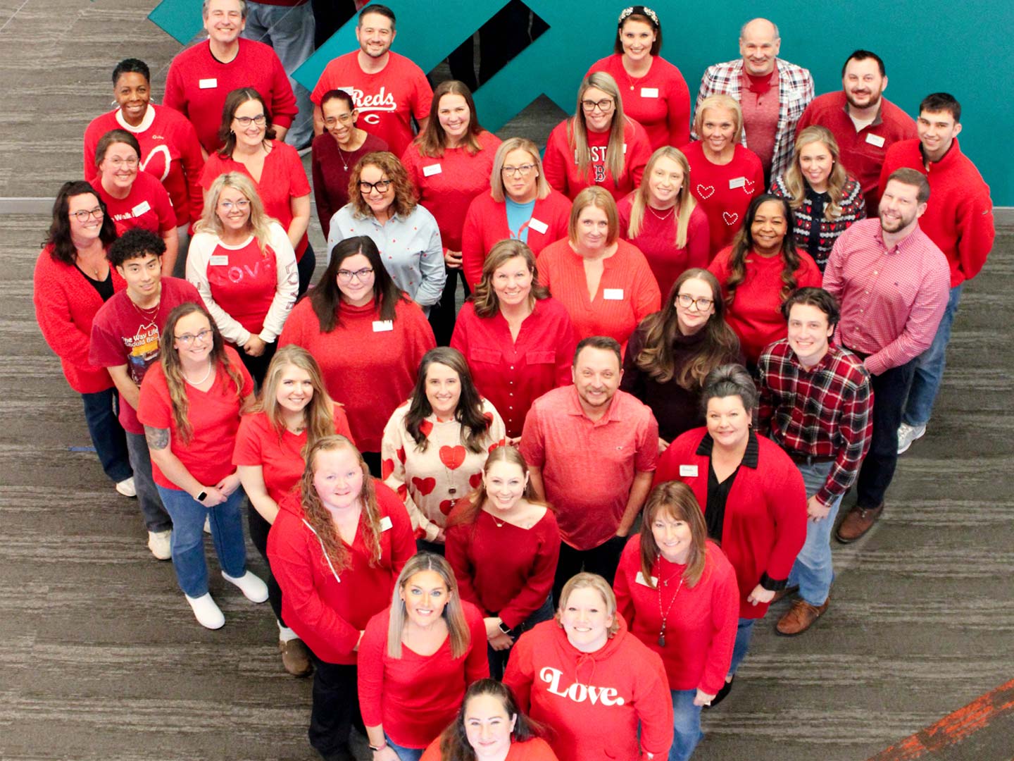 CCU team members wearing red shirts and standing in a heart shape