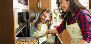 A mom and daughter baking cookies together.