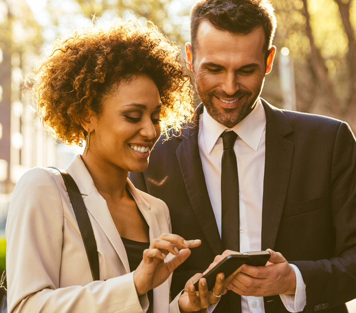 A pair of people view cellphones togther.